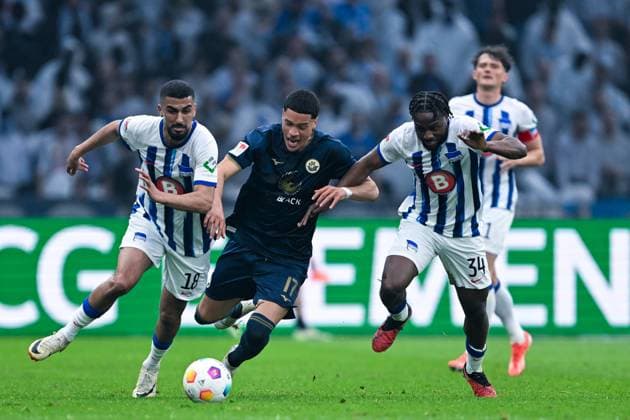 2. Bundesliga - Hertha BSC Berlin - FC Hansa Rostock am 12.04.2024 im Olympiastadion in Berlin Aymane Barkok (Hertha BSC Berlin) im Zweikampf gegen Jonas David (Rostock) und Deyovaisio Zeefuik (Hertha BSC Berlin).