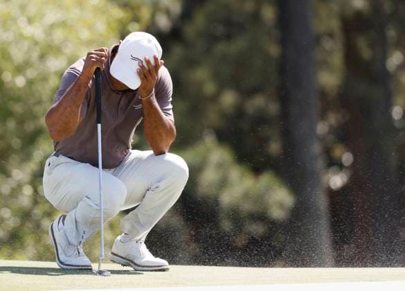 Sport Bilder des Tages Tiger Woods covers his face as gusting wind blows sand from the bunker across the eighteenth green during the second round of the Masters Tournament at Augusta National Golf Club in Augusta, Georgia on Friday, April 12, 2024. Woods finished the day at one-over-par.  AUG202404121006 JOHNxANGELILLO