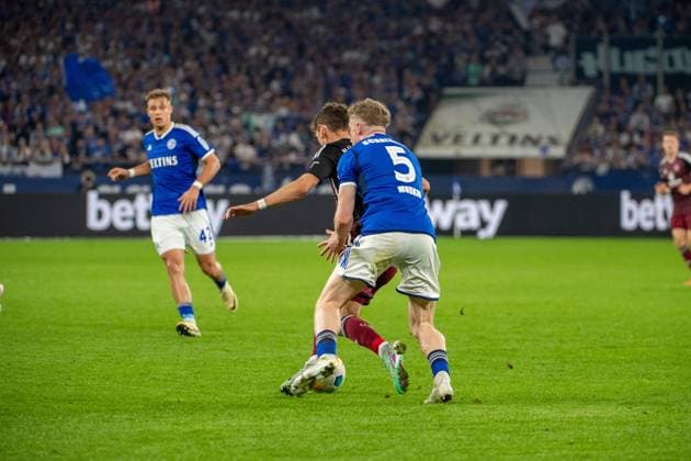 2. Fussball Bundesliga: FC Schalke 04 - 1. FC Nürnberg; 13.04.2024 Derry John Murkin (FC Schalke 04, 5), im Zweikampf mit Benjamin Goller (1. FC Nürnberg, 14); 2. Fussball Bundesliga. FC Schalke 04 - 1. FC Nürnberg, 29. Spieltag, am 13.04.2024, Veltins Arena, Gelsenkirchen. DFL REGULATIONS PROHIBIT ANY USE OF PHOTOGRAPHS AS IMAGE SEQUENCES AND OR QUASI-VIDEO.