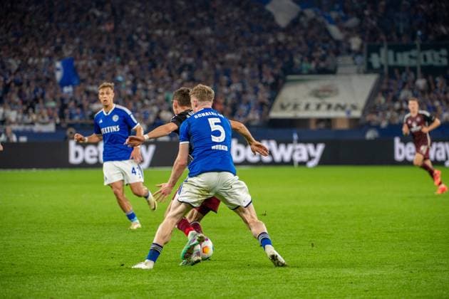 2. Fussball Bundesliga: FC Schalke 04 - 1. FC Nürnberg; 13.04.2024 Derry John Murkin (FC Schalke 04, 5), im Zweikampf mit Benjamin Goller (1. FC Nürnberg, 14); 2. Fussball Bundesliga. FC Schalke 04 - 1. FC Nürnberg, 29. Spieltag, am 13.04.2024, Veltins Arena, Gelsenkirchen. DFL REGULATIONS PROHIBIT ANY USE OF PHOTOGRAPHS AS IMAGE SEQUENCES AND OR QUASI-VIDEO.