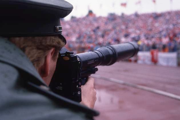 Ein Polizist fotografiert mit einer Kamera mit Teleobjektiv, Sicherheit, Polizeischutz, allgemein, feature, Randmotiv, Symbolfoto Daenemark (DEN) - Spanien (ESP) 2:3, Fussball EM EURO 1988 in Deutschland, 15.06.1988 im Niedersachsenstadion Hannover, Â *** A policeman takes a photo with a camera with telephoto lens, security, police protection, general, feature, border motif, symbol photo Denmark DEN Spain ESP 2 3, European Football Championship EURO 1988 in Germany, 15 06 1988 in the Niedersachsenstadion Hannover, Â