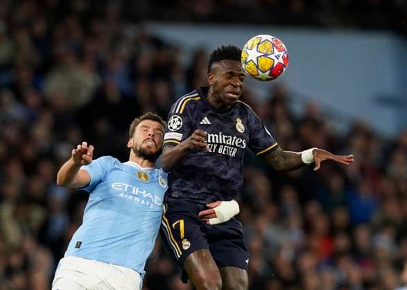 Manchester, England, 17th April 2024. Ruben Dias of Manchester City tussles with Vinicius Junior of Real Madrid during the UEFA Champions League Quarter Final 2nd Leg match at the Etihad Stadium, Manchester. Picture credit should read: Andrew Yates Sportimage EDITORIAL USE ONLY. No use with unauthorised audio, video, data, fixture lists, club league logos or live services. Online in-match use limited to 120 images, no video emulation. No use in betting, games or single club league player publications. SPI-3082-0055