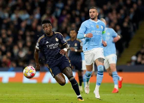 Manchester, England, 17th April 2024. Vinicius Junior of Real Madrid gets clear of Kyle Walker of Manchester City during the UEFA Champions League Quarter Final 2nd Leg match at the Etihad Stadium, Manchester. Picture credit should read: Andrew Yates Sportimage EDITORIAL USE ONLY. No use with unauthorised audio, video, data, fixture lists, club league logos or live services. Online in-match use limited to 120 images, no video emulation. No use in betting, games or single club league player publications. SPI-3082-0061
