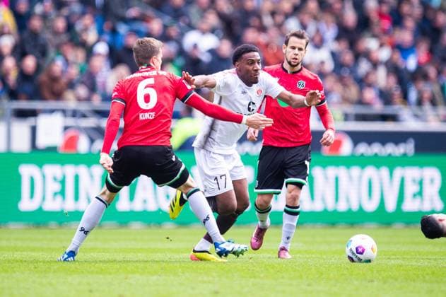 21.04.2024 - Fußball, 2023 2024, 1. Bundesliga, 30. Spieltag, Hannover 96 - FC St. Pauli: (L-R) Fabian Kunze (Hannover), Oladapo Afolayan (Pauli) DFL REGULATIONS PROHIBIT ANY USE OF PHOTOGRAPHS AS IMAGE SEQUENCES AND OR QUASI-VIDEO.