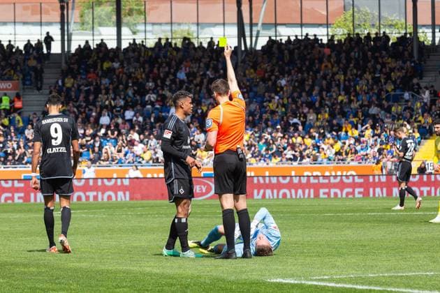 Fußball I Herren I Saison 2023-2024 I 2. Bundesliga I 31. Spieltag I Eintracht Braunschweig - Hamburger SV I 27.04.2024 Schiedsrichter Daniel Siebert zeigt nach einem Foulspiel an Ron-Thorben Hoffmann (1, Eintracht Braunschweig) Ransford-Yeboah Königsdörffer (11, Hamburger SV) die gelbe Karte. Braunschweig Eintracht-Stadion Niedersachsen Deutschland