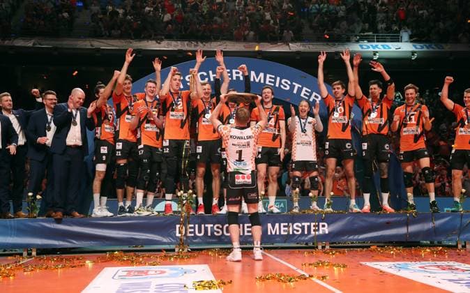 Deutscher Meister BR Volleys Adam Kowalski mit Meisterschale vor der Mannschaft Freude Emotion Jubel Volleyball Playoff Finale 5.Spiel Bundesliga Herren Saison 2023 2024 28.04.2024 BR Volleys Berlin BRV vs. VfB Friedrichshafen