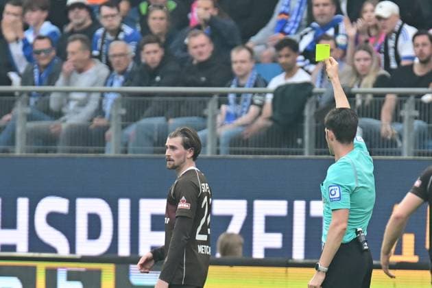 Fußball I Herren I 2023-2024 I 2. Bundesliga I 32. Spieltag I Hamburger SV - FC St. Pauli I 3.5.2024 Dr. Matthias Jöllenbeck (Schiedsrichter) mit der gelben Karte für Connor Metcalfe (24, FC St. Pauli) Hamburg Volksparkstadion Hamburg Deutschland