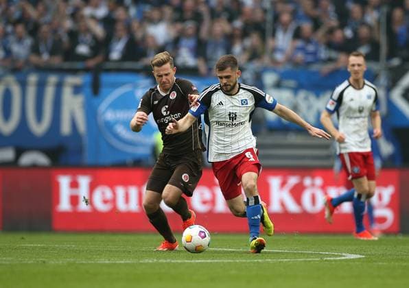03.05.2024, Fussball 2. Bundesliga 2023 2024, 32. Spieltag, Hamburger SV - FC St. Pauli , im Volksparkstadion Hamburg. (L-R) Johannes Eggestein (FC St. Pauli) gegen Lukasz Poreba (Hamburg)