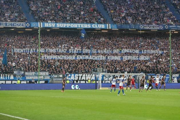 03.05.2024, xtgx, Fussball - 2.Bundesliga, Hamburger SV - FC St.Pauli emspor, v.l. Fans vom HSV halten ein Spruchband, Banner, Plakat hoch Identität und Konstanz statt grosse Namen und einfache Lösungen. Strippenzieher entmachten, Kuhne Verpiss Dich! (DFL DFB REGULATIONS PROHIBIT ANY USE OF PHOTOGRAPHS as IMAGE SEQUENCES and or QUASI-VIDEO) Hamburg