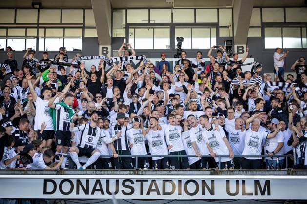 Die Spieler des SSV Ulm feiern zusammen mit Ihren Fans auf der Tribuene den Aufstieg in die 2. Fussball Bundesliga. Ganz vorne dabei Johannes Reichert (SSV Ulm 1846, 05) mit dem Mikrofon. ¨¨GER, SSV Ulm 1846 Fussball vs. FC Viktoria Koeln, Fußball, 3. Liga, 36. Spieltag, Spielzeit 2023 2024, 04.05.2024, ¨DFB DFL regulations prohibit any use of photographs as image sequences and or quasi-video.,¨ SSV Ulm 1846 Fussball - FC Viktoria Koeln , Fußball, 3. Liga, 36. Spieltag, Spielzeit 2023 2024, 04.05.2024 Ulm