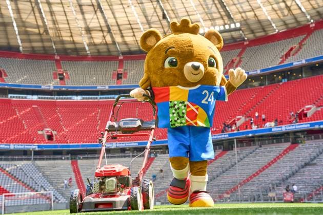Munich, Bavaria, Germany - May 13, 2024: The mascot of UEFA EURO, EM, Europameisterschaft,Fussball 2024, a teddy bear called Albärt. Mascot of the European Championship, EM, Europameisterschaft symbolically mows the lawn of the Allianzarena pitch in Munich
