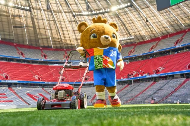 Munich, Bavaria, Germany - May 13, 2024: The mascot of UEFA EURO, EM, Europameisterschaft,Fussball 2024, a teddy bear called Albärt. Mascot of the European Championship, EM, Europameisterschaft symbolically mows the lawn of the Allianzarena pitch in Munich