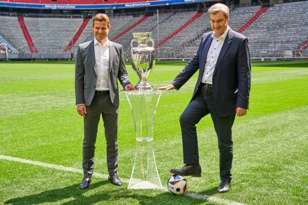 Munich, Bavaria, Germany - 13 May 2024: Prime Minister Dr. Markus Söder (CSU) together with FIFA referee Felix Brych on the soccer pitch of the Allianz Arena in Munich, next to the Henri Delaunay Cup of UEFA EURO, EM, Europameisterschaft,Fussball 2024