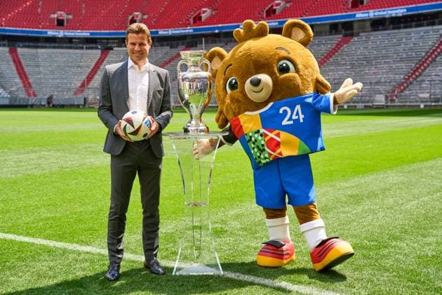 Munich, Bavaria, Germany - May 13, 2024: FIFA referee Felix Brych next to the Henri Delaunay Cup of UEFA EURO, EM, Europameisterschaft,Fussball 2024 on the soccer pitch at the Allianz Arena in Munich. EURO mascot Albärt next to the trophy