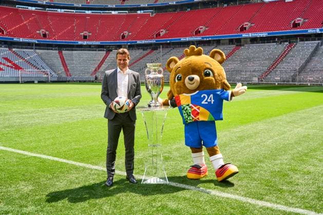 Munich, Bavaria, Germany - May 13, 2024: FIFA referee Felix Brych next to the Henri Delaunay Cup of UEFA EURO, EM, Europameisterschaft,Fussball 2024 on the soccer pitch at the Allianz Arena in Munich. EURO mascot Albärt next to the trophy