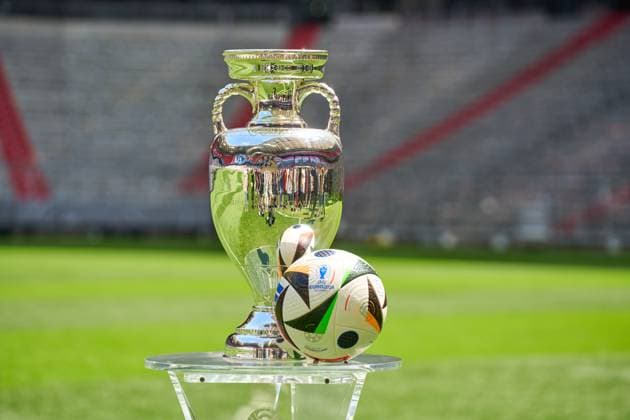Munich, Bavaria, Germany - 13 May 2024: Themed picture Football EURO 2024: Henri Delaunay Cup of UEFA EURO, EM, Europameisterschaft,Fussball 2024 together with the official match ball of the European Championship, EM, Europameisterschaft by Adidas on the pitch of the Allianz Arena in Munich