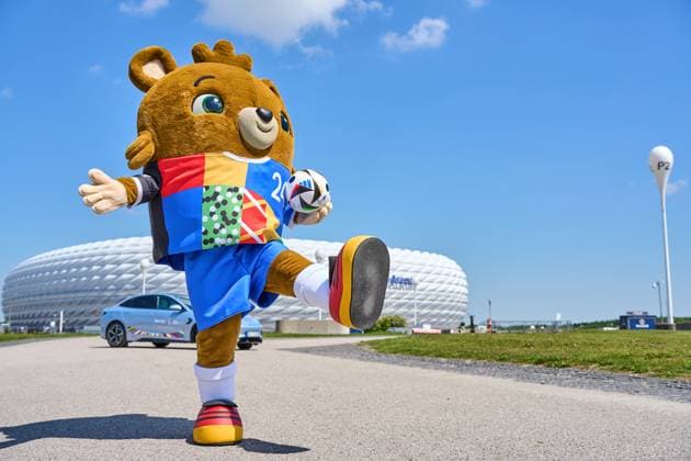 Munich, Bavaria, Germany - May 13, 2024: Mascot of the European Championship, EM, Europameisterschaft 2024 or European Football Championship in front of the Allianz Arena, with a BYD Seal electric car as sponsor and an Adidas match ball in the jersey