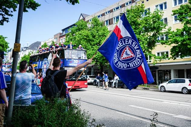 Fahne Holstein Kiel mit Bus im Hintergrund GER, Aufstiegsfeier Holstein Kiel, 20.05.2024 GER, Aufstiegsfeier Holstein Kiel, 20.05.2024 Kiel