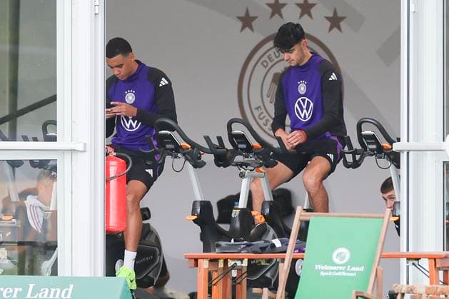 Jamal Musiala und Aleksandar Pavlovic sitzen im Zelt auf dem Fahrrad, Oeffentliches Training Tag 2, Trainingslager der deutschen Natiionalmannschaft, Ernst-Abbe-Sportfeld, 28.05.2024, Jena, Deutschland.