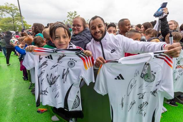 Reportage 31.05.2024 Ankunftsfest der deutschen Männer Nationalmannschaft bei adidas in Herzogenaurach bei strömenden Regen Der kleine Muaremou und sein Vater haben 11 Stunden an diesem Platz gewartet, die Ausbeute kann sich sehen lassen Herzogenaurach Bayern Deutschland