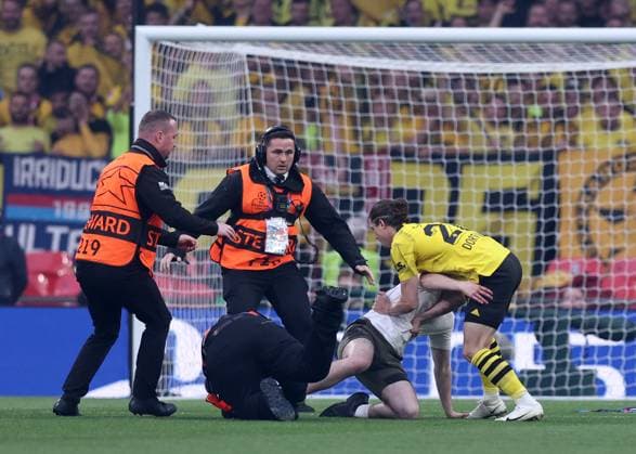Sport Bilder des Tages London, England, 1st June 2024. One of three pitch invaders makes it onto the pitch delaying the game Marcel Sabitzer of Borussia Dortmund helps stop him during the UEFA Champions League final match at Wembley Stadium, London. Picture credit should read: David Klein Sportimage EDITORIAL USE ONLY. No use with unauthorised audio, video, data, fixture lists, club league logos or live services. Online in-match use limited to 120 images, no video emulation. No use in betting, games or single club league player publications. SPI-3169-0071