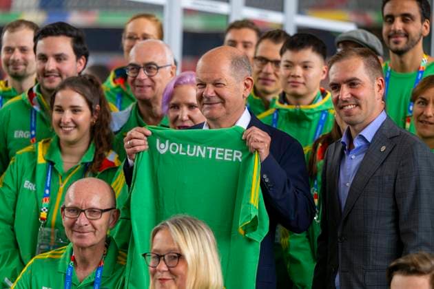 03.06.2024, Fussball Europameisterschaft 2024, Besuch von Bundeskanzler Olaf Scholz (mitte) im EM-Stadion München Fußball Arena. Hier beim Gruppenfoto mit einer Abordnung von Volunteers und Philipp Lahm (re).