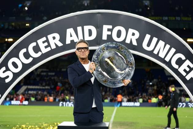 England Coach Robbie Williams celebrates with the trophy. England XI v World XI, Soccer Aid for Unicef 2024, Football, Stamford Bridge, London, UK, 09 Jun 2024 EDITORIAL USE ONLY No use with unauthorised audio, video, data, fixture lists, club league logos or live services. Online in-match use limited to 120 images, no video emulation. No use in betting, games or single club league player publications.  Copyright: xJamesxMarsh Shutterstockx 14523637ed