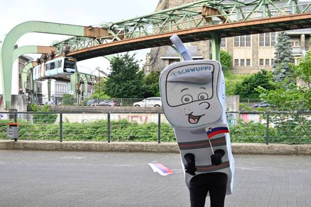 GER, UEFA Europameisterschaft 2024, Slowenisches Base Camp Wuppertal 12.06.2023,Wuppertal ,Stadion am Zoo, GER, UEFA Europameisterschaft 2024, Slowenisches Base Camp Wuppertal im Bild das Wuppertaler Maskottchen Schwuppi vor der Schwebebahn.