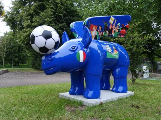 13.06,2024 Dortund, Aufbau Fanzone für die EURO 2024 auf der Festwiese im Westfalenpark Dortmund. Geflügelte Nashörner in den unterschiedlichsten Designs sind ein Wahrzeichen der Stadt. Hier ein extra Exemplar für die Euro. Es steht vor dem Eingang zur Fanzone des Parks. eflügelte Nashorn ist ein