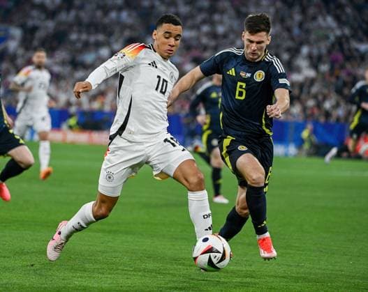 14.06.2024, xpsx, UEFA EURO, EM, Europameisterschaft,Fussball 2024 Vorrunde, Deutschland - Schottland v.l. Jamal Musiala (Deutsche Fussball Nationalmannschaft DFB), Kieran Tierney (Team Schottland) (DFL DFB REGULATIONS PROHIBIT ANY USE OF PHOTOGRAPHS as IMAGE SEQUENCES and or QUASI-VIDEO) München Bayern Deutschland (DEU)