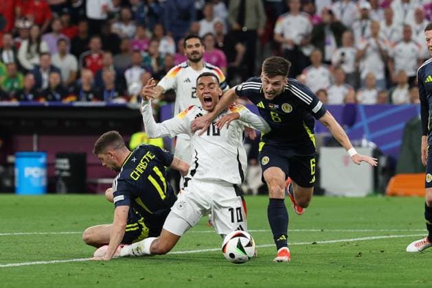 l-r: im Zweikampf, Aktion, mit Ryan Christie 11 (Schottland), Jamal Musiala 10 (Deutschland), Kieran Tierney 6 (Schottland), Deutschland vs. Schottland, Fussball, UEFA EURO, EM, Europameisterschaft,Fussball 2024, Gruppenphase, 1. Spieltag, 14.06.2024 DFB regulations prohibit any use of photographs as image sequences and or quasi-video Muenchen Bayern Deutschland