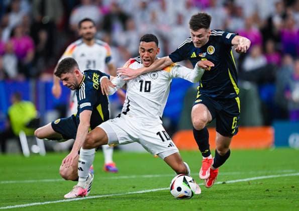 Ryan Christie (Scotland), Jamal Musiala (Germany) und Kieran Tierney (Scotland) kaempfen um den Ball, UEFA EURO, EM, Europameisterschaft,Fussball 2024 - Group A, Germany vs Scotland, Fussball Arena München am 14. June 2024 in München, Deutschland. (Foto von Silas Schueller DeFodi Images) Ryan Christie (Scotland), Jamal Musiala (Germany) und Kieran Tierney (Scotland) battle for the ball, UEFA EURO 2024 - Group A, Germany vs Scotland, Munich Football Arena on June 14, 2024 in Munich, Germany. (Photo by Silas Schueller DeFodi Images) Defodi-0580986077st