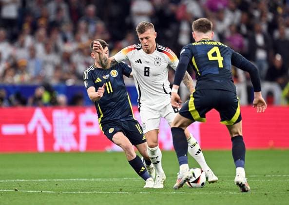 14.06.2024, xscotx, Fussball EM 2024, Deutschland - Schottland, emspor, v.l. Ryan Christie (Team Schottland), Toni Kroos (Deutsche Fussball Nationalmannschaft DFB), Scott Mctominay (Team Schottland) München