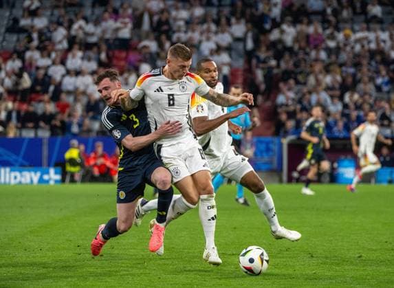 Fussball, Herren, Saison 2023 24, Euro 2024 Gruppe A (1. Spieltag) in München, Deutschland - Schottland, v. l. Andrew Robertson (Schottland), Toni Kroos (Deutschland), Jonathan Tah (Deutschland), 14.06. 2024, Copyright: xMatthiasxKochx