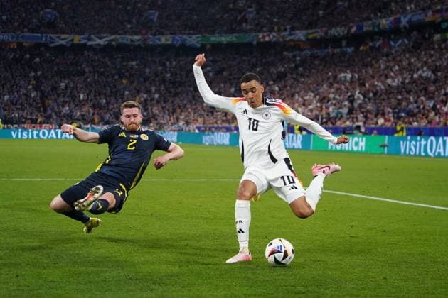 14.06.2024, Fussball UEFA EURO, EM, Europameisterschaft,Fussball 2024, Vorrunde, 1.Spieltag, Eröffnungsspiel Deutschland - Schottland, in der Fußball Arena München. Jamal Musiala (Deutschland) setzt sich durch gegen Anthony Ralston (Schottland)