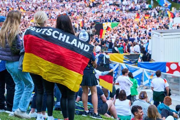 Munich, Bavaria, Germany - June 14, 2024: Germany fans with Germany flag and cheering in the UEFA EURO, EM, Europameisterschaft,Fussball 2024 fan zone during the opening match between Germany and Scotland in the public viewing area