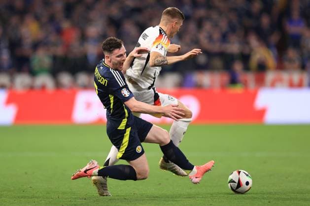 Football - UEFA EURO, EM, Europameisterschaft,Fussball 2024 - Group A - Germany v Scotland 14th June 2024 - UEFA EURO 2024 - Group A - Germany v Scotland - Andrew Robertson of Scotland is nudged off the ball by Toni Kroos of Germany - Photo: Simon Stacpoole Offside. Munich Germany Copyright: xSimonxStacpoolexOffside