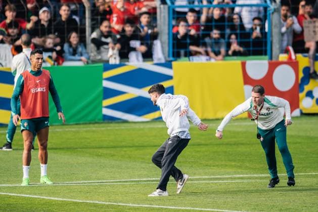 Portugal Public Training Session And press conference, PK, Pressekonferenz - UEFA EURO, EM, Europameisterschaft,Fussball 2024 A security man is chasing a fan after the fan storms the pitch to take a photo with Cristiano Ronaldo during the public training session of Portugal ahead of the UEFA EURO 2024 in Gutersloh, Germany, on June 14, 2024. Gutersloh Germany  Copyright: xHeshamxElsherifx originalFilename:elsherif-notitle240614_npGKY.jpg