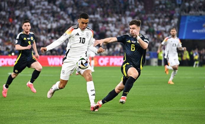 Fussball, Europameisterschaft, EURO 2024, Gruppe A, Allianz Arena München: Deutschland - Schottland; Jamal Musiala (GER), Kieran Tierney (SCO). Aktion