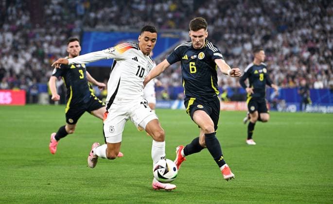 Fussball, Europameisterschaft, EURO 2024, Gruppe A, Allianz Arena München: Deutschland - Schottland; Jamal Musiala (GER), Kieran Tierney (SCO). Aktion
