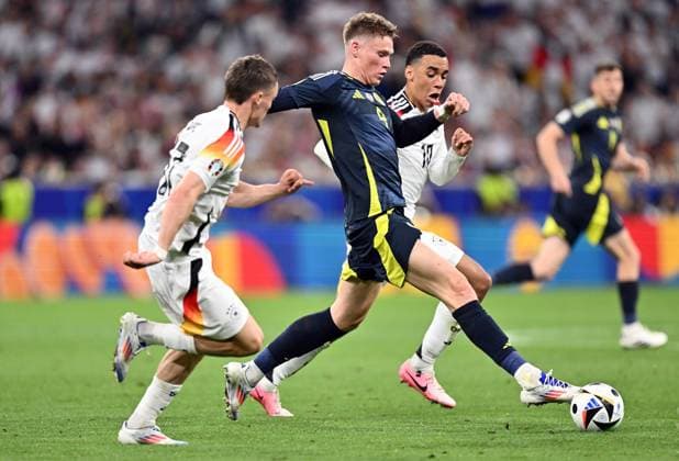 14.06.2024, xscotx, Fussball EM 2024, Deutschland - Schottland, emspor, v.l. Florian Wirtz (Deutsche Fussball Nationalmannschaft DFB), Scott Mctominay (Team Schottland), Jamal Musiala (Deutsche Fussball Nationalmannschaft DFB) München