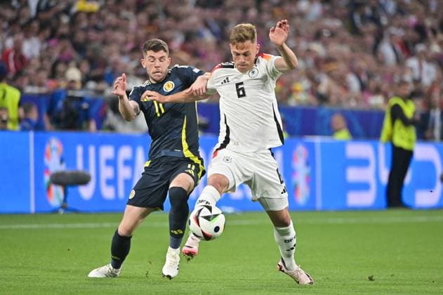 Bild zeigt: v.l.n.r. Ryan Christie (11, Schottland), Joshua Kimmich (6, Deutschland), 14.06.2024, München, Fussball, Europameisterschaft, Deutschland - Schottland, EVENT REGULATIONS PROHIBIT ANY USE OF PHOTOGRAPHS AS IMAGE SEQUENCES AND OR QUASI-VIDEO.