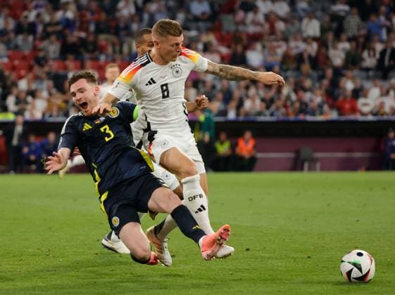 14.06.2024, Fussball Europameisterschaft, Deutschland vs Schottland, Allianz Arena Muenchen, im Bild: Andrew Robertson (Schottland) vs Toni Kroos (Deutschland), Jonathan Tah (Deutschland)