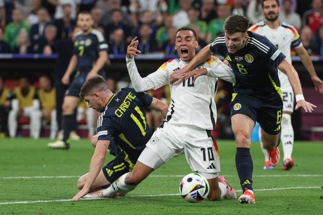 Sport Bilder des Tages EM 2024: Deutschland - Schottland am 14.06.2024 in der Allianz Arena in München Jamal Musiala (Deutschland 10) gegen Ryan Christie (Schottland 11) und Kieran Tierney (Schottland 6)