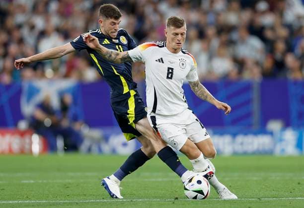 14.06.2024, Fussball, Europameisterschaft, Germany - Scotland, GER, Munich, Munich Football Arena, Bild: v. li. Ryan Christie (Scotland, 11) und Toni Kroos (Germany, 8) Copyright: HMBxMedia xHeikoxBecker