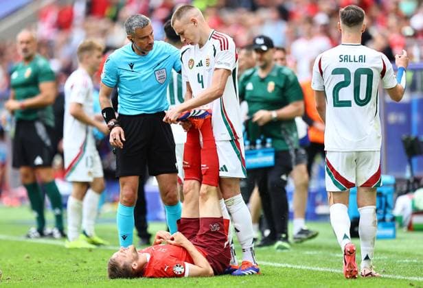 Attila Szalai of Hungary stretches the legs of Silvan Widmer of Switzerland as he goes down with cramp during play Hungary v Switzerland, UEFA European Championship, EM, Europameisterschaft 2024, Group A, Football, Cologne Stadium, Cologne, Germany, 15 Jun 2024 EDITORIAL USE ONLY No use with unauthorised audio, video, data, fixture lists, club league logos or live services. Online in-match use limited to 120 images, no video emulation. No use in betting, games or single club league player publications. Copyright: xMichaelxZemanek Shutterstockx 14539265bt