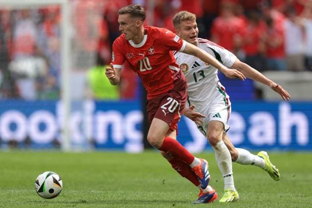 Cologne, Germany, 15th June 2024. Michel Aebischer of Switzerland is pursued by Andras Schafer of Hungary during the UEFA European Championships match at Cologne Stadium, Cologne. Picture credit should read: Jonathan Moscrop Sportimage EDITORIAL USE ONLY. No use with unauthorised audio, video, data, fixture lists, club league logos or live services. Online in-match use limited to 120 images, no video emulation. No use in betting, games or single club league player publications. SPI-3181-0046