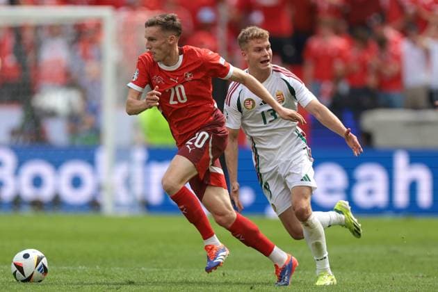 Cologne, Germany, 15th June 2024. Michel Aebischer of Switzerland is pursued by Andras Schafer of Hungary during the UEFA European Championships match at Cologne Stadium, Cologne. Picture credit should read: Jonathan Moscrop Sportimage EDITORIAL USE ONLY. No use with unauthorised audio, video, data, fixture lists, club league logos or live services. Online in-match use limited to 120 images, no video emulation. No use in betting, games or single club league player publications. SPI-3181-0047