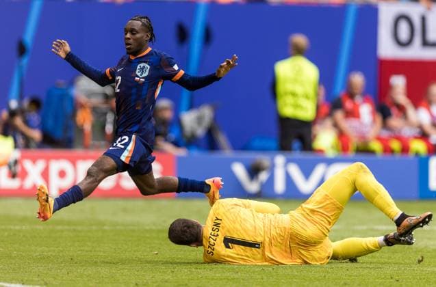 16th June 2024; Volksparkstadion, Hamburg, Germany; Euro 2024 Group D Football, Poland versus Netherlands; Jeremie Frimpong (NED) is denied by the diving goalkeeper Wojciech Szczesny (POL) who collects the through ball  ActionPlus12655225 TomaszxJastrzebowski