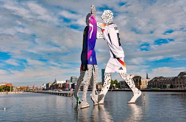 EURO 2024, Citydressing Berlin, Skulptur Molecule Man in den verschiedenen Deutschland Trikots Seit Start der Fussball-EM haben die drei Figuren Molecul-Man nahe dem Treptower ein XXL-Fussball-Trikot angezogen. Molecul-Man im EM-Zeichen